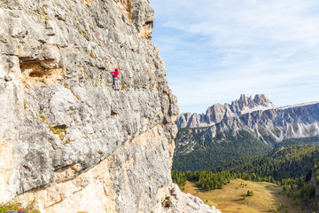 Italy, Cortina d'Ampezzo, woman climbing in the Dolomites mountains