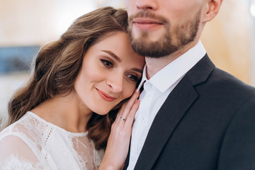 Classic portrait of lovely wedding couple, bride leaned to her husband