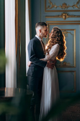 Gorgeous and stylish wedding couple in beautiful warm backlight sensual looking to each other