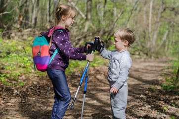 Girl and boy walk or hike through the forest in early spring