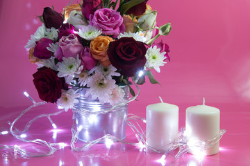 Vase of bouquet Roses and white candlestick lighting bulb and Vase of bouquet Roses. 