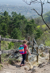 Girl walk or hike through the forest and rocks in early spring