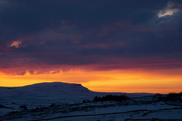 sunrise over penyghent covered in snow