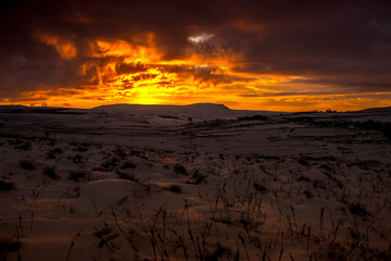 sunrise over penyghent covered in snow