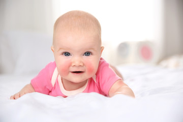 Pretty baby lying on bed at home, closeup