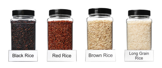 Set of plastic jars with labels filled by different uncooked rices on white background