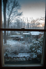 looking through the window at snow at sunrise on the first day of spring