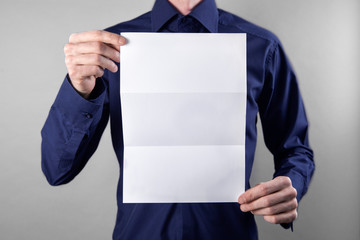 A man holding white booklet