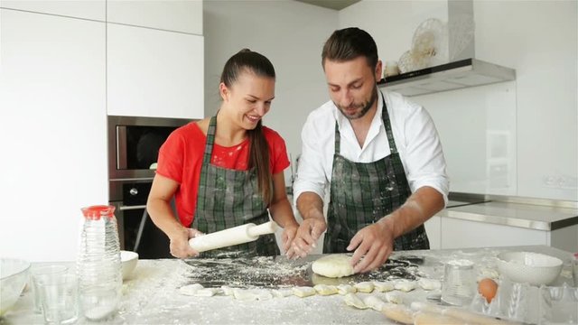 Funny Couple Kneading Dough And Having Fun With Flour On The Kitchen.
