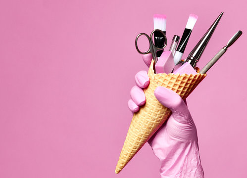 Manicure and pedicure abstract concept. Hand hold  waffles cone with instruments for nails salon and spa brush nail file 