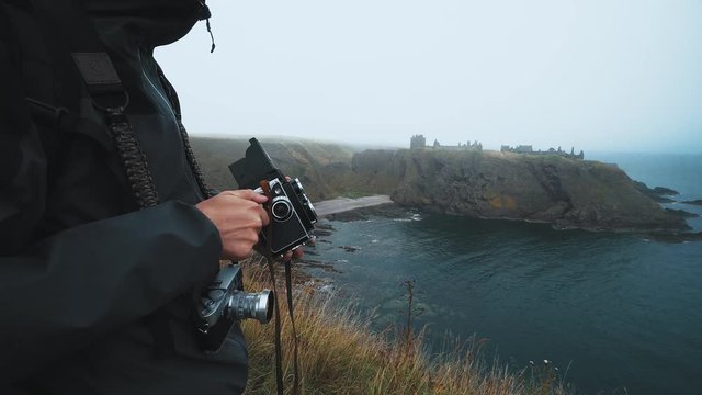 A man winds film in an old twin lens reflex camera