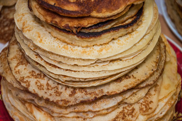 Very large stack of pancakes in the contest during the celebration Russian Shrovetide (pancake week) at school
