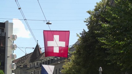 The national flag of Switzerland over Zurich. - Powered by Adobe