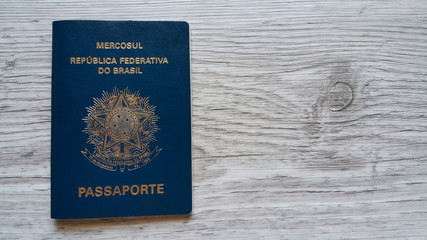 Naklejka premium Brazilian passport with wooden background