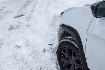 Winter car in deep snow on the road dangerous winter snowstorm driving and tire performance safety...