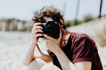 Junger Mensch fotografiert im Urlaub im Sommer mit einer Spiegelreflex Kamera
