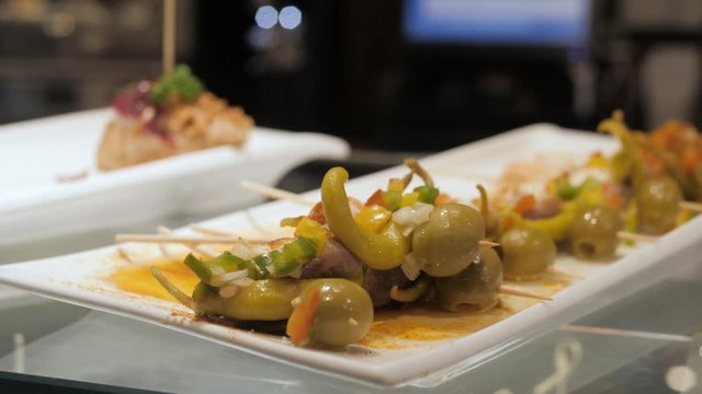 Showcase window display assortiment with tapas &ndash; traditional Spanish sandwiches in a cafe in Barcelona, Spain close up macro