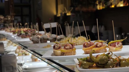 Showcase window display assortiment with tapas – traditional Spanish sandwiches in a cafe in Barcelona, Spain close up macro