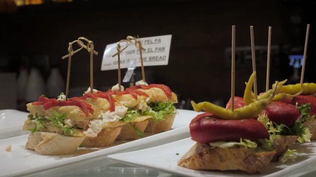 Showcase window display assortiment with tapas &ndash; traditional Spanish sandwiches in a cafe in Barcelona, Spain close up macro