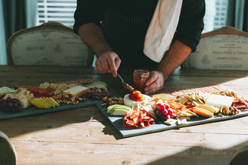 A chef plating a charcuterie board.