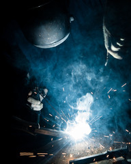 Man welding iron with a protective mask