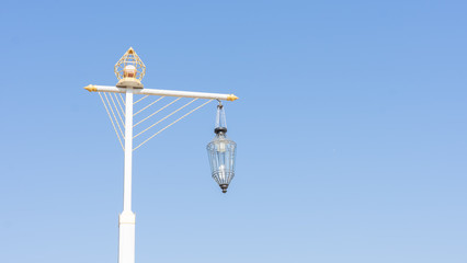 A street light, light pole, lamppost, street lamp,  or lamp standard in blue sky .