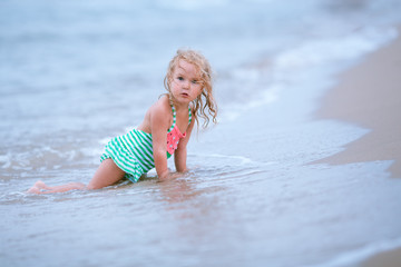 Little cute happy girl swims in the sea, Spain