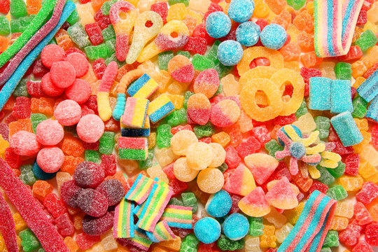 Assorted variety of sour candies includes extreme sour soft fruit chews, keys, tart candy belts and straws.
