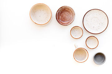 Ceramic tableware pattern. Empty plates and mugs on white background top view copy space