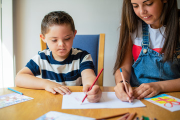 Girl helping her brother to draw