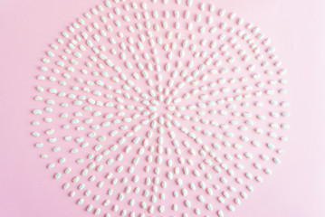 Dry beans scattered in circle on pink background