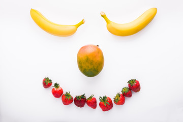 Fresh fruits shaped as smiley face, top view
