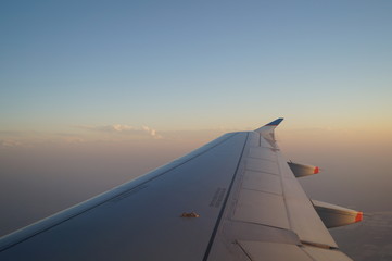 Fototapeta na wymiar the view from the window of the aircraft, the wing of the aircraft against the sky, sunset