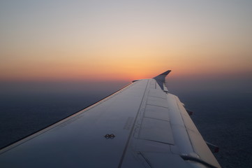 Fototapeta na wymiar the view from the window of the aircraft, the wing of the aircraft against the sky, sunset