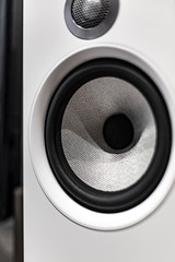 White loudspeaker close up still with grey woofers