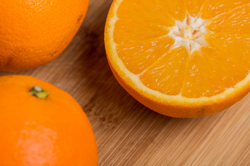 Orange fruit cut on halves on a wooden surface