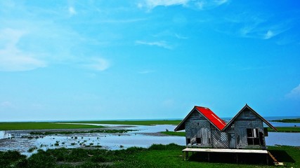 Old Twins Wooden Houses are Located in the Middle of the Lake. Twin house is Abandons on Wetland at Southern of Thailand.