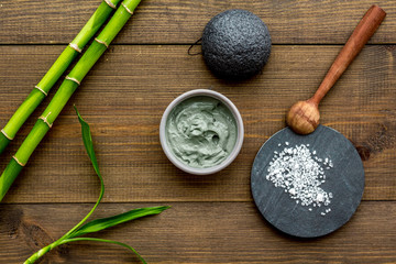 Skin cleansing and detox. Bamboo charcoal powder cosmetics on dark wooden background top view