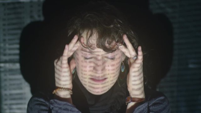 Young woman has headache & stress from spreadsheet numbers projected on her face