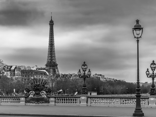 Fototapeta na wymiar Moody cityscape with Pont Alexandre III bridge, Seine river and Eiffel Tower in Paris, France in black and white treatment