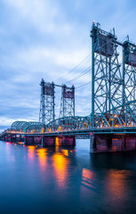 Lifting sectional Columbia Interstate bridge over the Columbia River with colorful evening lights in Portland area