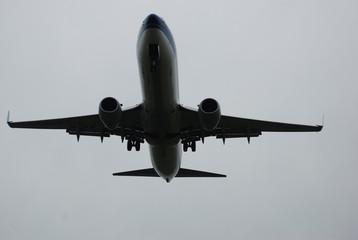Airplane on descending, wheels out, low hight, on the way to the runway strip on the rainy day