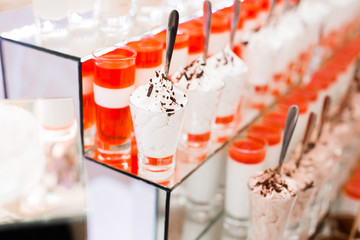 Delicious and tasty dessert table with cupcakes shots at reception closeup