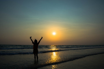 silhouette of woman on the beach at sunset