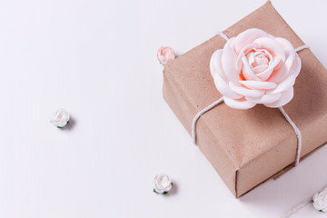 wrapped gift with a rose on a white background. top view copy space