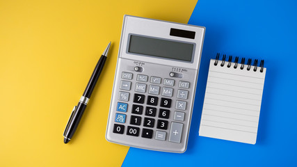 Calculator on vivid yellow and blue background