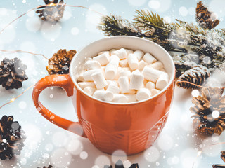 Orange mug with hot chocolate with melted marshmallow.Holiday concept. Flat lay, top view.ot cocoa with marshmallow in a  mug surrounded by winter things.Christmas hot beverage ideas.