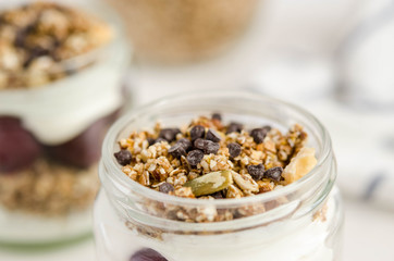Homemade granola with cherry, yogurt in a glass jar
