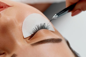 Eyelash Extension Procedure. Woman Eye with Long Eyelashes. Lashes, close up, macro, selective focus.Cosmetics and makeup.