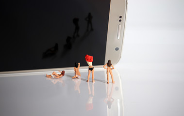 Miniature women changing clothes. The concept of women's human rights violations.